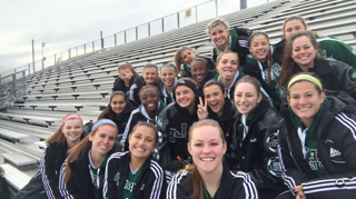 The girls soccer team gathers on the bleachers for a picture