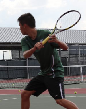 Ian Calvagel, 10, hits a backhand while warming up for his singles match.