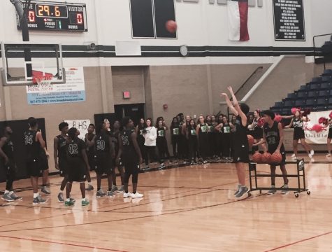 Members of the varsity basketball team run drills in front of the crowds for Basketball Madness.