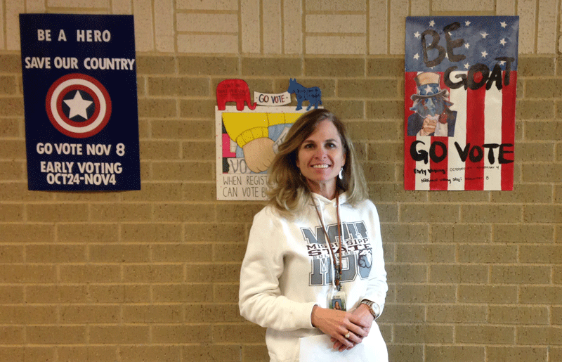Mrs. Mitchell stands in front of the LRHS Government posters