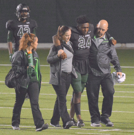 Trainers assist an injured player off the field.