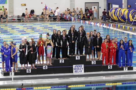 The LRHS Girls Swim Team takes their place on the podium.