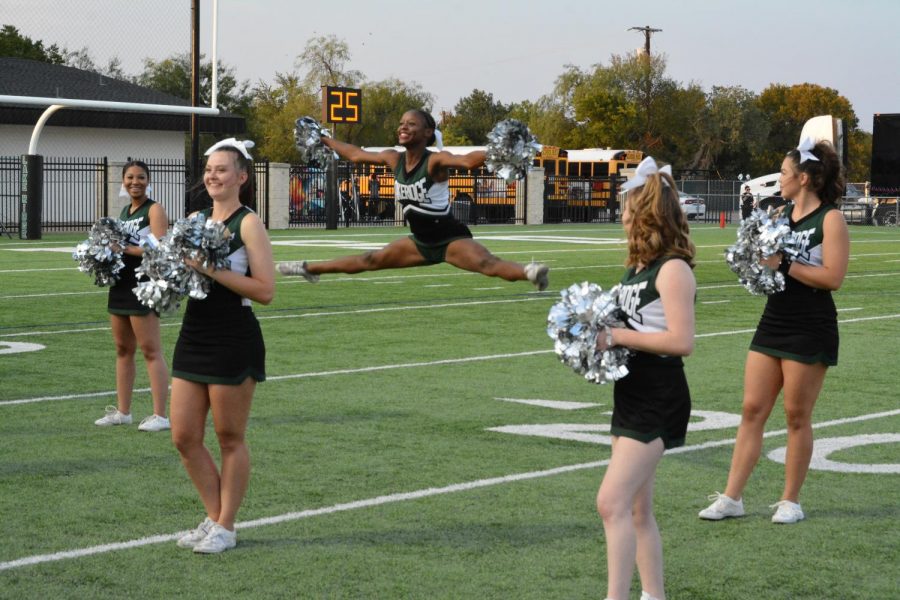 Cheerleaders encourage the crowd during football game.
