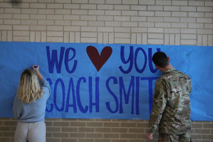 Students sign a banner honoring Coach Smith.