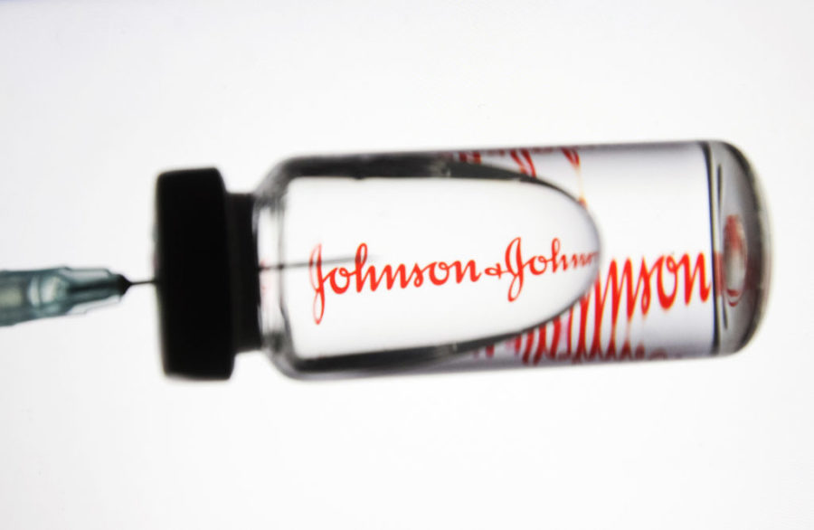 UKRAINE - 2020/11/24: In this photo illustration a medical syringe and a vial with fake coronavirus vaccine seen in front of the Johnson & Johnson logo. (Photo Illustration by Pavlo Gonchar/SOPA Images/LightRocket via Getty Images)