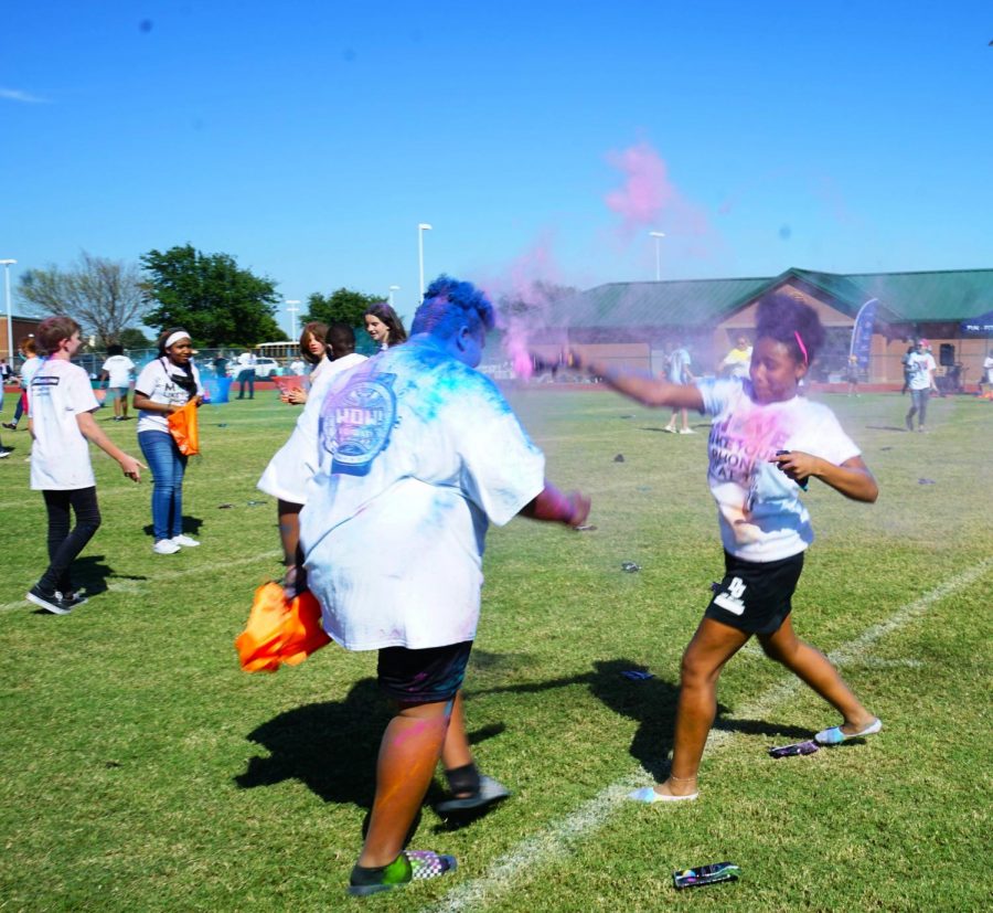 Andris Conley throws her color powder at Mani Martin Sept 23 on the Danny Jones football field.  
 Students who raised enough money for the Danny Jones fundraiser got to leave their 7th and 8th period clases to participate in the Color Battle,  where they played games and threw packs of colored powder at each other. 