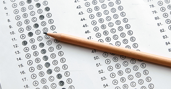 Standardized test form with answers bubbled in and a pencil, focus on anser sheet