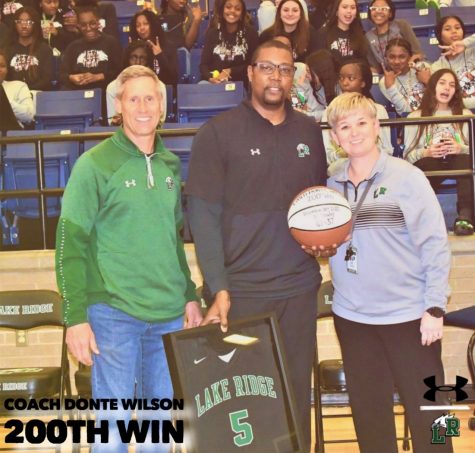 Boys Basketball Head Coach Wilson (middle) is recognized for his 200th win by Football Head Coach Kirk Thor (left) and Principal Ashley Alloway (right) during the DeSoto game.