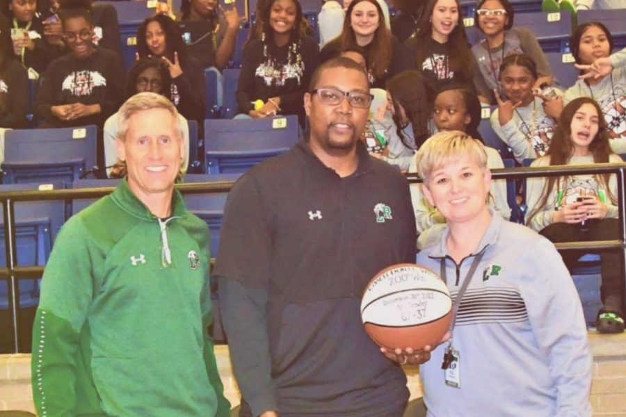 Boys Basketball Head Coach Wilson (middle) is recognized for his 200th win by Football Head Coach Kirk Thor (left) and Principal Ashley Alloway (right) during the DeSoto game. Courtesy of Tyler Quisenberry (ENN Staff).